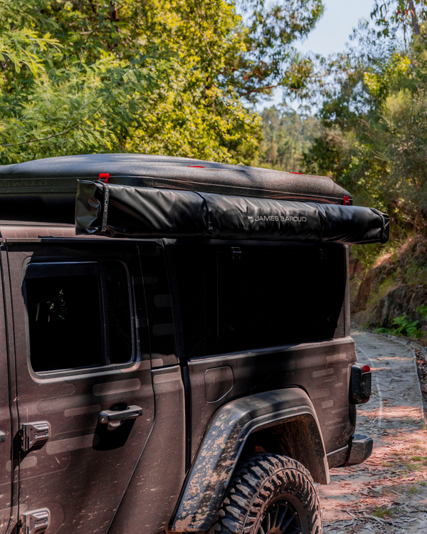 James Baroud Hartschalen-Dachzelt Odyssey Magma montiert auf einem Hardtop auf einem Offroad-Fahrzeug. Dachzelt ist eingeklappt. Mit Montierter Markise an der Seite.