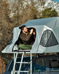 James Baroud Stoff Klappzelt Vision montiert auf Fahrzeug. Aufgebaut mit Leiter Zustieg. Geöffneter Einstieg.