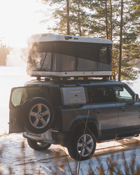 James Baroud Hartschalen-Dachzelt Evasion weiß montiert auf einem Offroad-Fahrzeug. Dachzelt ist offen.