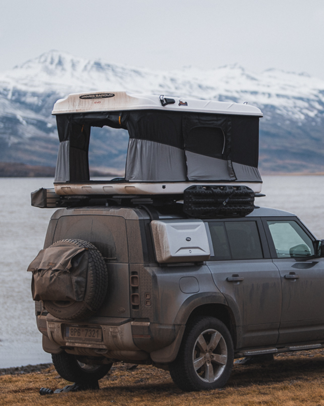 James Baroud Hartschalen-Dachzelt Evasion weiß montiert auf einem Offroad-Fahrzeug. Dachzelt ist offen. Mit Montierter Markise.