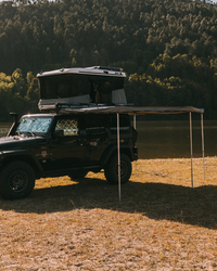 James Baroud Facon 270° Markise montiert an einem Offroad-Fahrzeug mit Dachzelt. Mit Stützen.