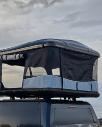 James Baroud Hartschalen-Dachzelt Odyssey schwarz montiert auf einem Offroad-Fahrzeug. Dachzelt ist offen.