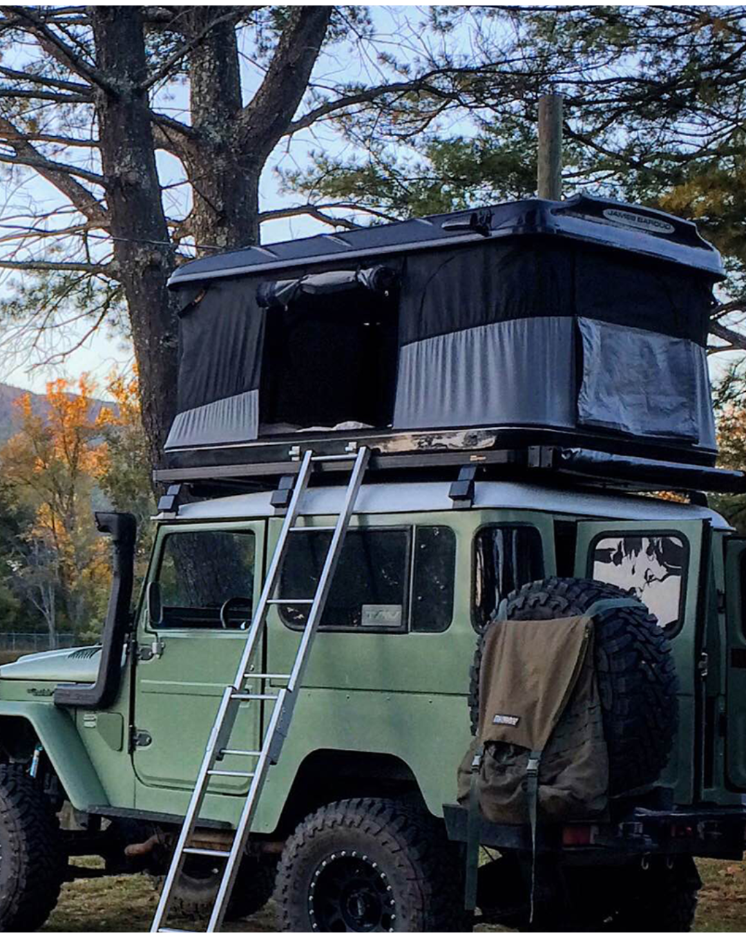 James Baroud Hartschalen-Dachzelt Evasion schwarz montiert auf einem Offroad-Fahrzeug. Mit Leiter und offenem Eingang.