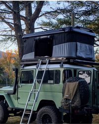 James Baroud Hartschalen-Dachzelt Evasion schwarz montiert auf einem Offroad-Fahrzeug. Mit Leiter und offenem Eingang.