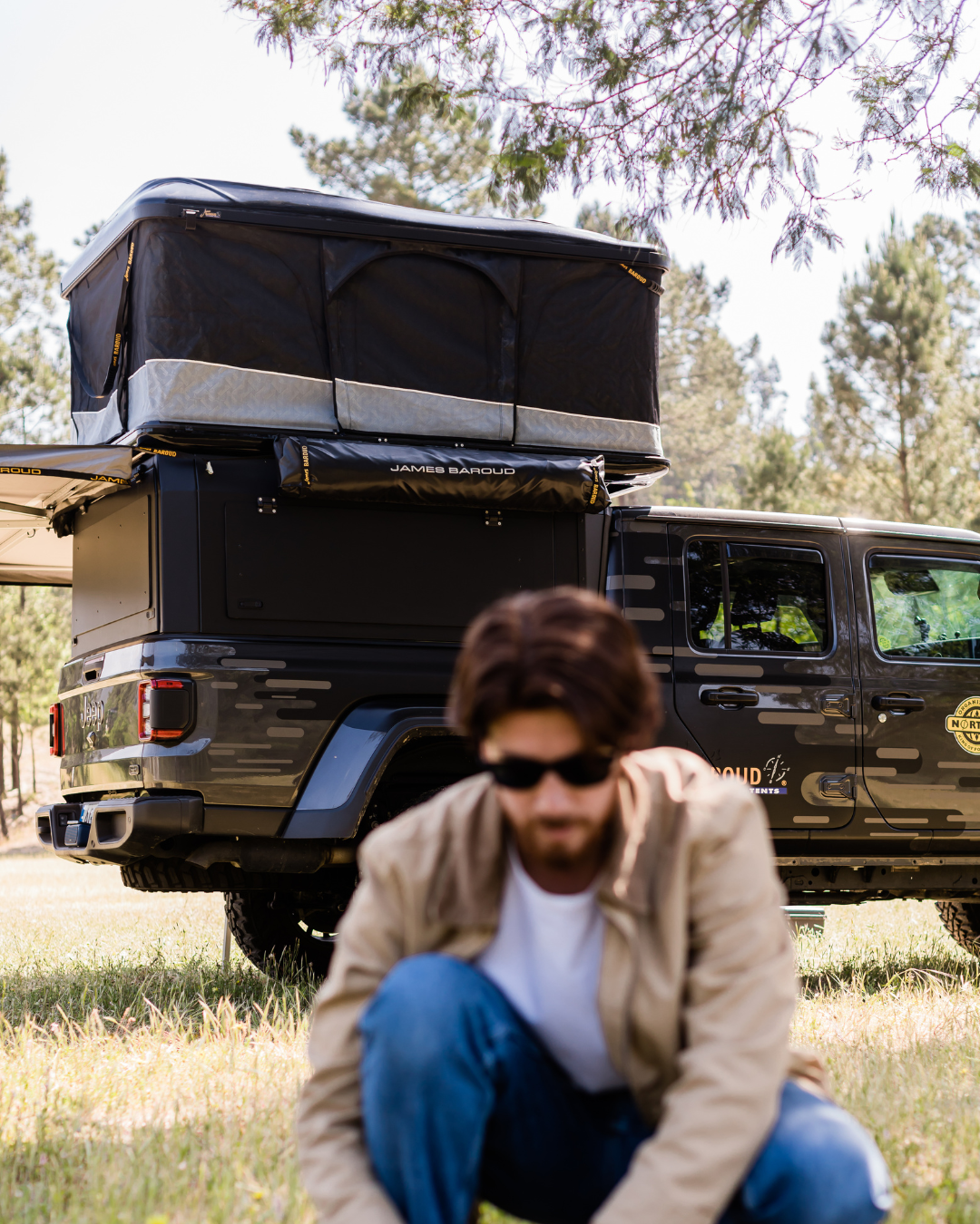 James Baroud Hartschalen-Dachzelt Odyssey schwarz montiert auf einem Offroad-Fahrzeug. Dachzelt ist offen.
