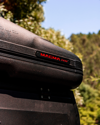 James Baroud Hartschalen-Dachzelt Odyssey Magma montiert auf einem Offroad-Fahrzeug. Detailbild vom Magma Logo.