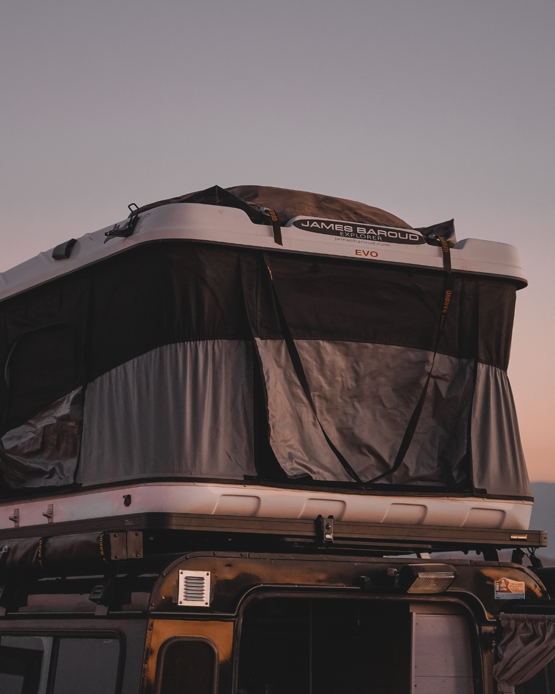 James Baroud Hartschalen-Dachzelt Grand Raid schwarz montiert auf einem Offroad-Fahrzeug. Dachzelt ist aufgebaut. Gepack auf dem Dach.