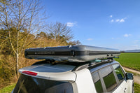 James Baroud Hartschalen-Dachzelt  montiert auf einem Fahrzeug. Dachzelt ist abgebaut. Schnallen sind zu sehen.