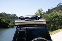 James Baroud Hartschalen-Dachzelt Grand Raid weiß geschlossen montiert auf einem Offroad-Fahrzeug. Mit Gepäck auf dem Dach.