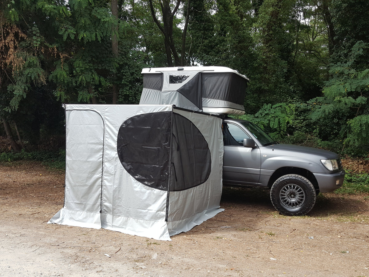 Aufgebaute Markise mit Seitenwänden und geöffnetem Fenster an einem Offroad-Fahrzeug. Montiert an der Seite des Autos.
